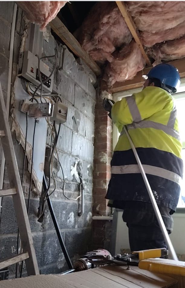 First fix wiring being run through a loft during a full rewire
